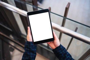 Boş beyaz masaüstü ekranlı, elinde siyah tablet bilgisayar tutan bir kadının görüntüsü 