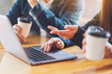 Bir grup iş adamı toplantıda sunum için dizüstü bilgisayar kullanıyor.