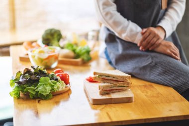 Closeup image of a female chef finish cooking whole wheat sandwich in kitchen