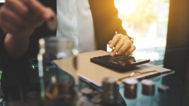 Tasarruf ve finansal konsept için para biriktiren, biriktiren ve kavanoza para koyan bir iş kadınının yakın plan görüntüsü