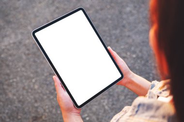 Üst görüntüde elinde siyah bir tablet olan beyaz ekranlı sokak arka planında bir kadının görüntüsü var.