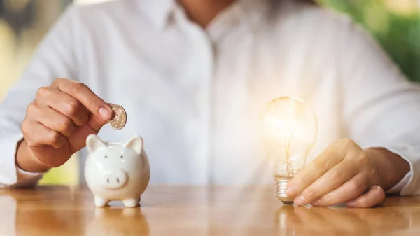 Woman Putting Coins Piggy Bank While Holding Light Bulb Saving — Fotografia de Stock
