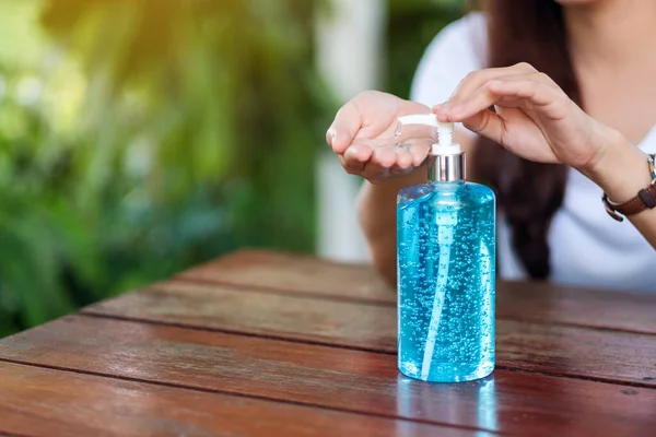 Sağlık ve Covid-19 konsepti için alkol jeli kullanan ve uygulayan bir kadının yakın plan görüntüsü