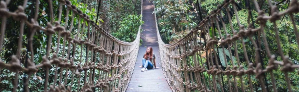 Una Joven Sentada Puente Cable Puente Colgante Selva —  Fotos de Stock