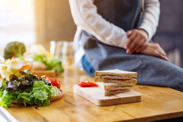 Mutfakta buğday sandviçi pişiren kadın şefin yakın plan görüntüsü.