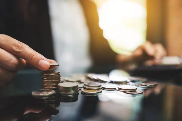 お金や金融の概念を保存するためのテーブルの上にコインを計算し 積み重ねるビジネスマン — ストック写真