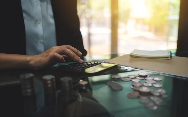 お金と金融の概念を節約するためのテーブルの上にコインスタックと計算ビジネスマンの女性 — ストック写真