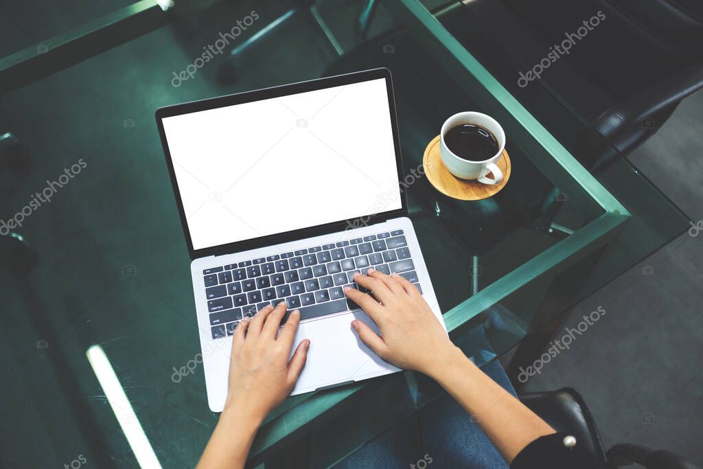Top view mockup image of a businesswoman using and typing on laptop computer with blank white desktop screen in the office
