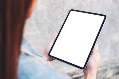 Üst görüntüde elinde siyah bir tablet olan beyaz ekranlı sokak arka planında bir kadının görüntüsü var.