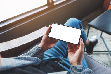 Boş beyaz masaüstü ekranlı cep telefonu tutan bir kadının görüntüsü 