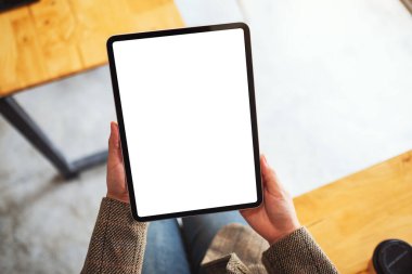 Boş beyaz masaüstü ekran ile siyah tablet pc taşıyan bir kadının en üst görünüm görüntüsü 