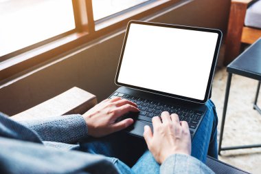 Mockup image of a woman using and typing on tablet keyboard with blank white desktop screen as a computer pc 