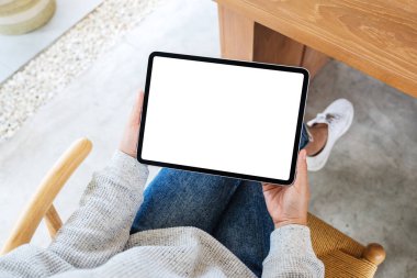 Boş beyaz masaüstü ekran ile siyah tablet pc taşıyan bir kadının en üst görünüm görüntüsü 