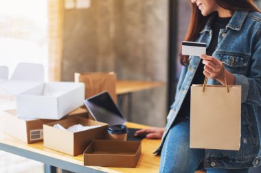 Masada posta kutusuyla online alışveriş için kredi kartı ve tablet kullanan bir kadının yakın plan resmi