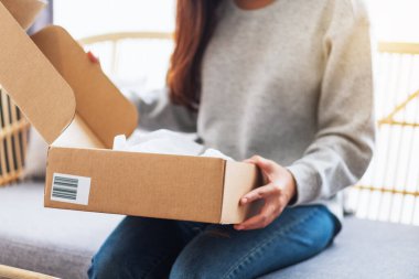Posta kutusunu eve teslim ve online alışveriş için alan ve açan bir kadının görüntüsünü kapat