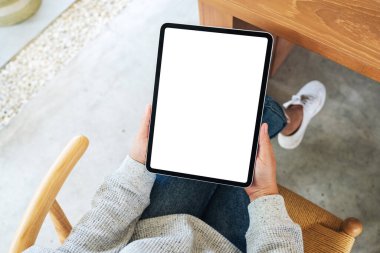 Boş beyaz masaüstü ekran ile siyah tablet pc taşıyan bir kadının en üst görünüm görüntüsü