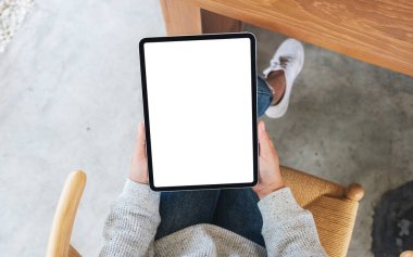 Boş beyaz masaüstü ekran ile siyah tablet pc taşıyan bir kadının en üst görünüm görüntüsü