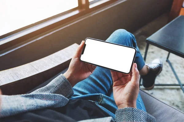 Boş beyaz masaüstü ekranlı cep telefonu tutan bir kadının görüntüsü 