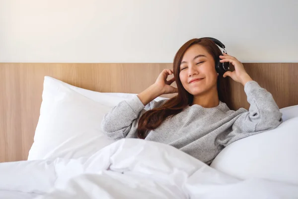 Beautiful Asian Woman Enjoy Listening Music Headphone While Lying White — Foto Stock