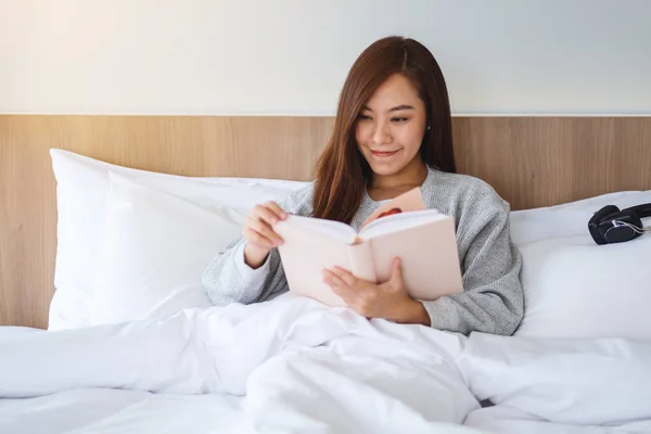 Closeup Image Beautiful Young Woman Reading Book White Cozy Bed — Zdjęcie stockowe