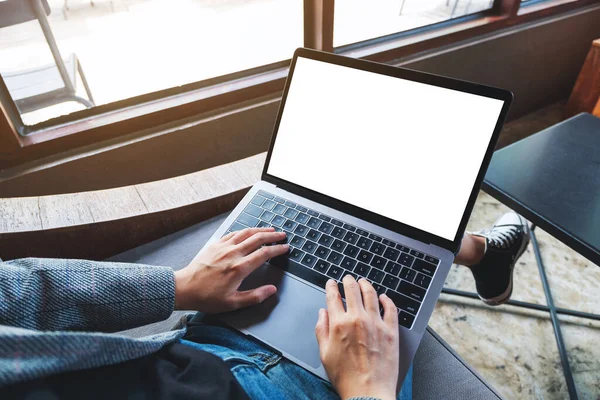 Boş beyaz masaüstü ekran ile dizüstü bilgisayarı kullanan ve yazan bir kadının en üst görünüm görüntüsü 