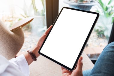 Boş beyaz masaüstü ekranlı siyah tablet bilgisayar tutan bir kadının görüntüsü