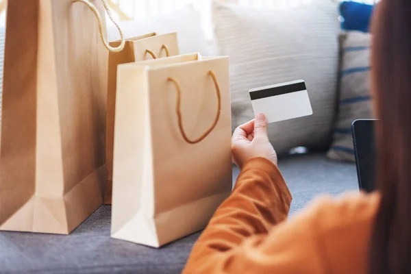 一名年轻女子在网上购物时使用手机及信用卡的照片 — 图库照片