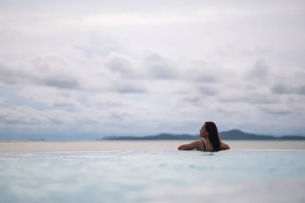 Una Joven Mujer Asiática Relajándose Piscina Infinita Mirando Una Hermosa Imagen de archivo