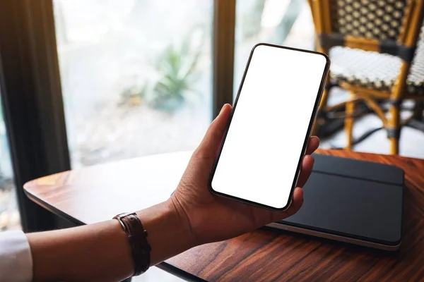 Kafede Boş Beyaz Ekranlı Bir Cep Telefonunun Ele Tutuşma Görüntüsü Stok Resim