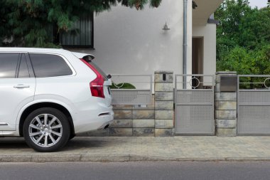 Modern bir konut binasının kapısında beyaz araba..