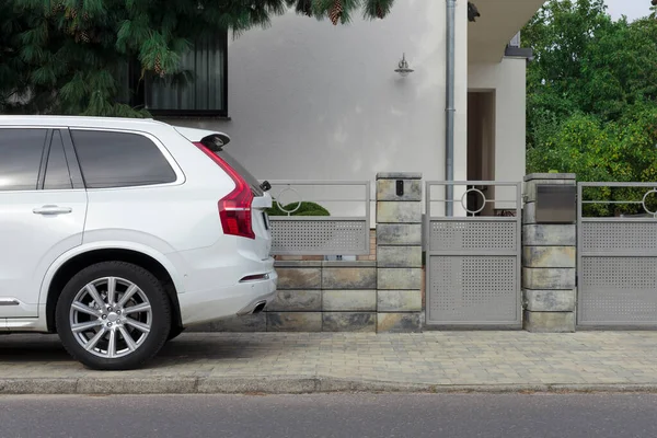 Modern bir konut binasının kapısında beyaz araba..