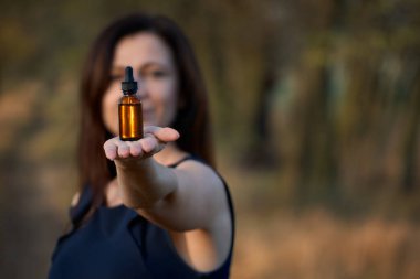 Doğa bitkisel kozmetik, konsept görüntü. Düşüren bir sağlık görevlisini tutan kadınlar. şişe.