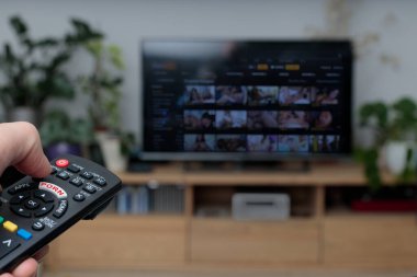 Porno TV - Pornografi. El ele tutuşan televizyon kumandası. Porno izliyordum. TV uzaktan kumandası önplanda
