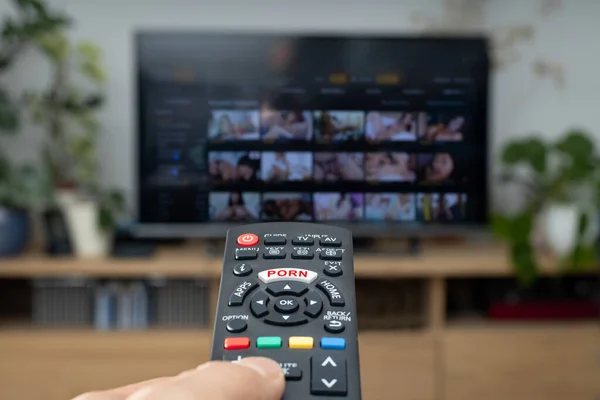 Person Watches Porn Home Remote Control Foreground Blurry Background Television — Stock Photo, Image