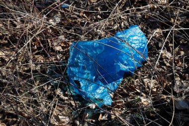 Yerde eski mavi plastik bir paket, çöp ve plastik bir sorun var. Bir çevre felaketi