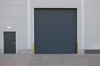 Fabrika, depo ya da hangar olarak kullanılan paten kapısı ya da paten panjuru. Açık havada.