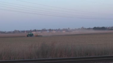 Tarlada saban süren yeşil traktör. Tarımda tarım işi, tarım sektörü