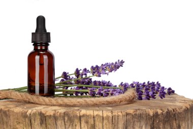 Model, ahşap bir masanın üstüne yerleştirilmiş bir damlacık ve lavanta çiçeği. Beyaz arkaplan, alanı kopyala.