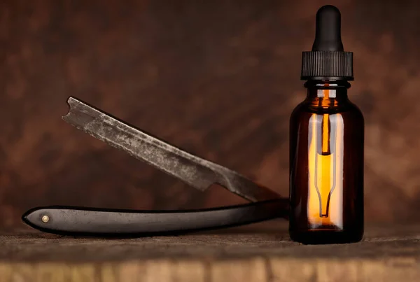 Amber bottle of beard oil, an old razor. Vintage style mockup oil beard. MOCK-UP