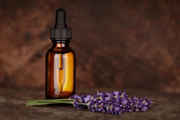 Lavender essential oil, natural face and body treatment. Mock-up of lavender medicinal product, dropper and lavender flowers on natural background. Copy space for text.