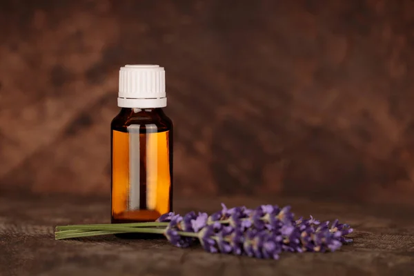 Lavender essential oil, natural face and body treatment. Mock-up of lavender medicinal product, small bottle and lavender flowers on natural background. Copyspace for text.