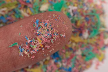 Plastik, mikro plastik ve çevresel kirlilik izleri olan parmak yakın plan..