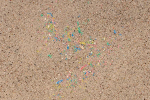 Micro plastic in sand on beach, colorful plastic particles.