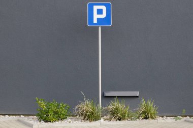 Parking space sign, in front of the building.