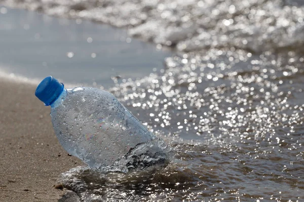 Plastic bottle pollution on sandy beach. PET plastic bottle garbage left away on sandy beach