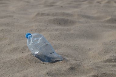 Land and sea pollution, environmental problem, used plastic bottle on the seashore.