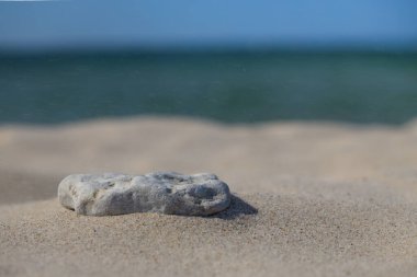 Stones on a white sand beach background. Minimal creative composition background for cosmetics or product presentation. Front view