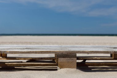 Wooden pallet against the beach on a sunny day. Shot from the front, copy space. Mock-up for zero waste product.