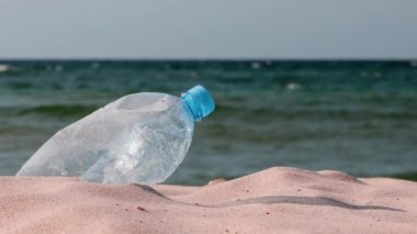 Gezegenin çöp kirliliği. Plaj kumsalında boş plastik şişe. İnsan yaşamının sonuçları.