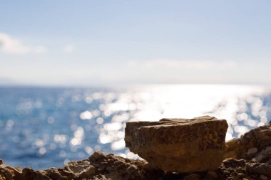 Montaj ürünleri sergisi için güzel mavi deniz arka planına sahip boş bir alan. Sahilin arka planında taş ve su..